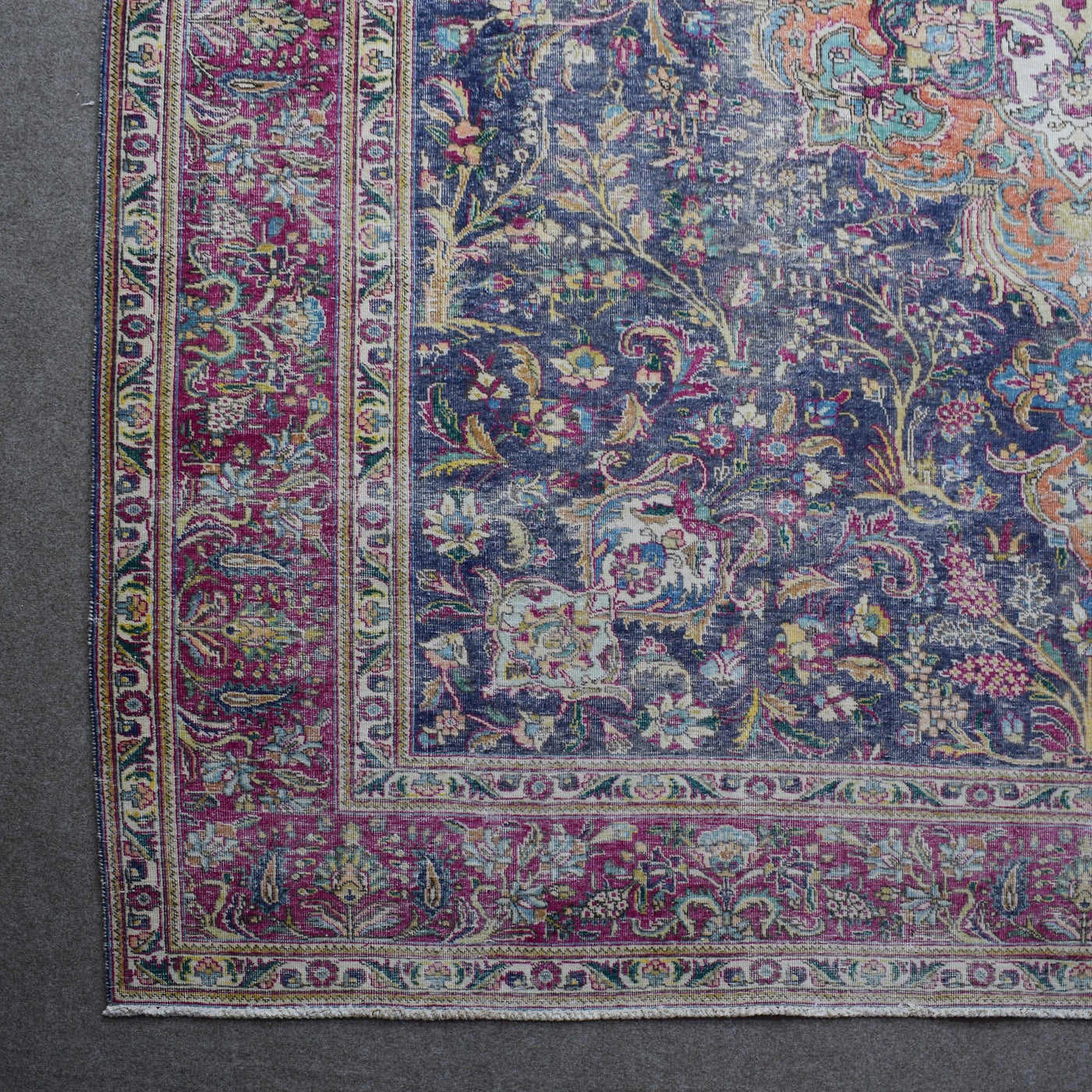 Corner detail of Persian rug with decorative floral border and traditional Persian motifs