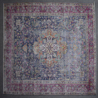 Hand knotted Persian rug photographed at an angle showing overall medallion layout and distressed navy tones