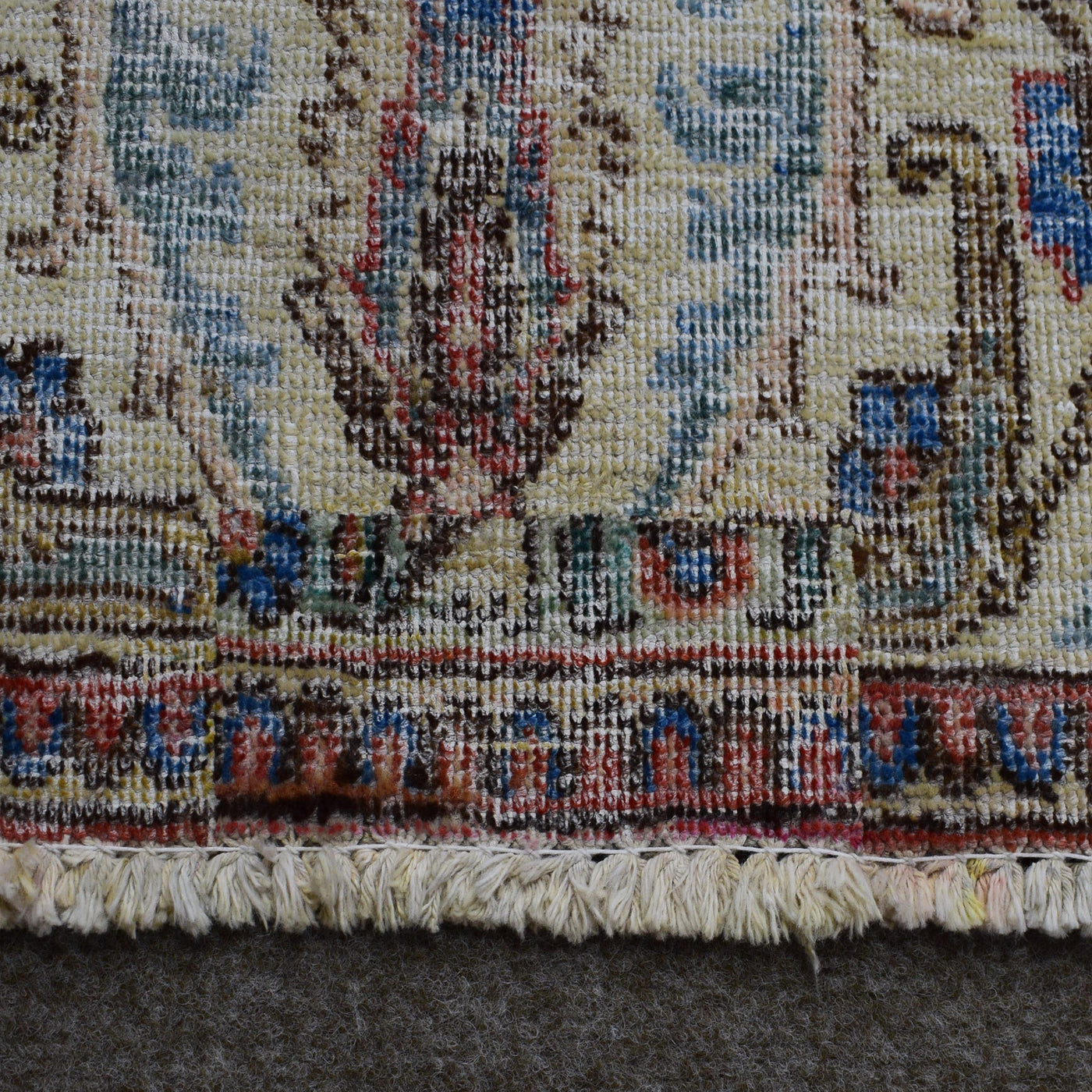 Close up of Persian rug border with colorful floral motifs and intricate guard stripes