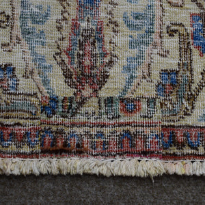 Close up of Persian rug border with colorful floral motifs and intricate guard stripes