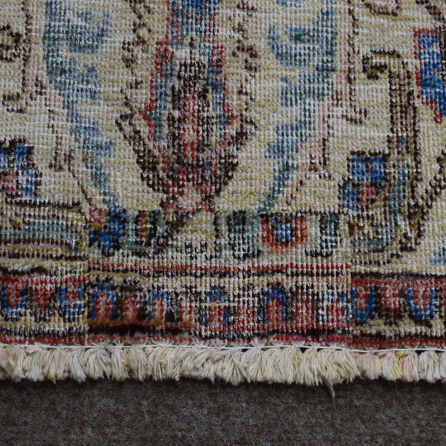 Close up of Persian rug border with colorful floral motifs and intricate guard stripes