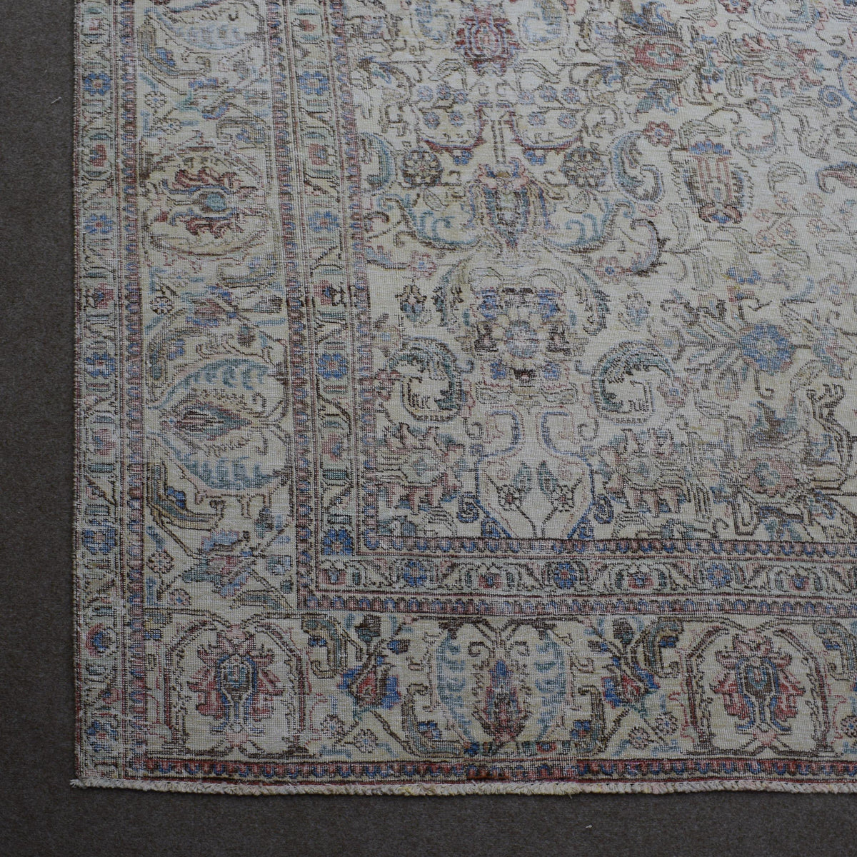 Corner detail of Persian rug with decorative border and classic floral motifs