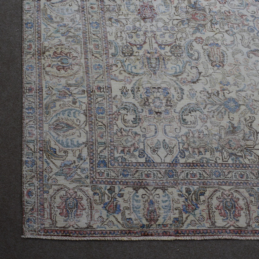 Corner detail of Persian rug with decorative border and classic floral motifs