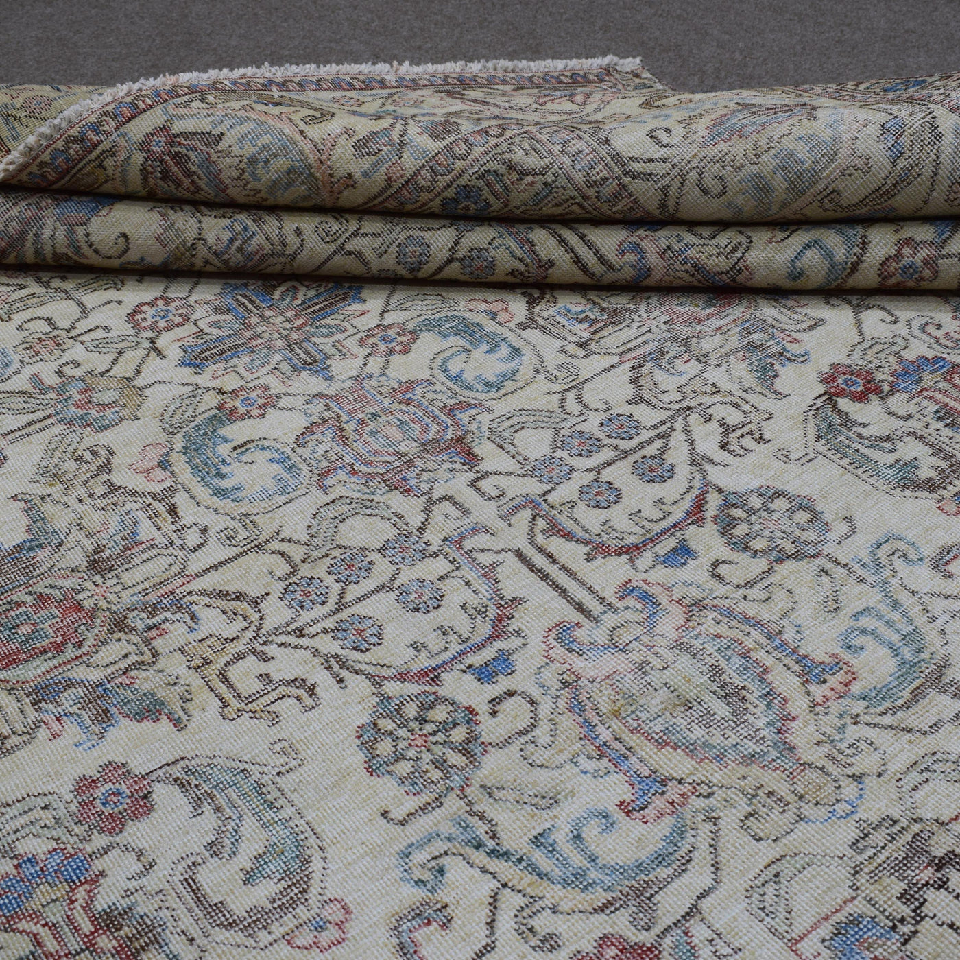 Folded vintage Persian rug showing pile height and dense hand knotted construction