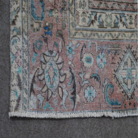Detailed view of distressed Persian rug pattern with faded navy background and ornamental motifs