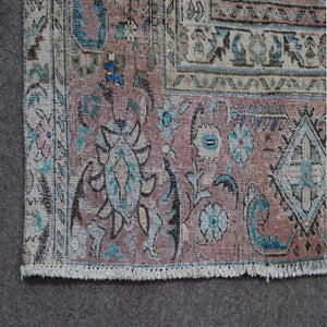 Detailed view of distressed Persian rug pattern with faded navy background and ornamental motifs