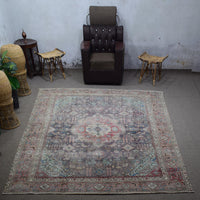 Large distressed vintage Persian rug 285x381 cm styled in interior showing muted navy tones and classic medallion design