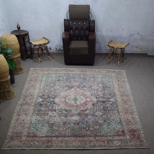 Large distressed vintage Persian rug 285x381 cm styled in interior showing muted navy tones and classic medallion design