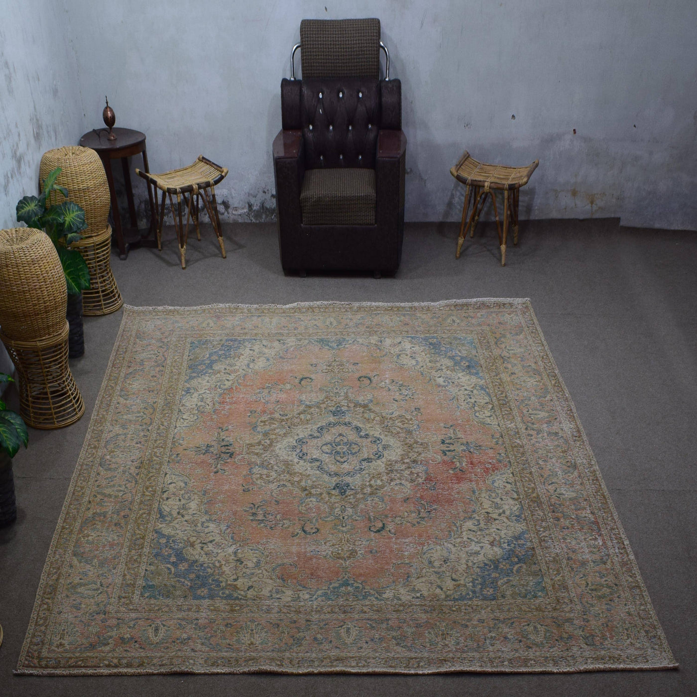 Large distressed vintage Persian rug 303x363 cm styled in interior showing soft coral tones and traditional medallion design