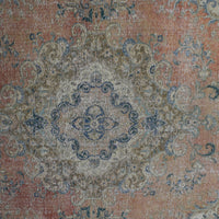 Detailed view of vintage Persian rug pattern featuring intricate floral medallion on coral background