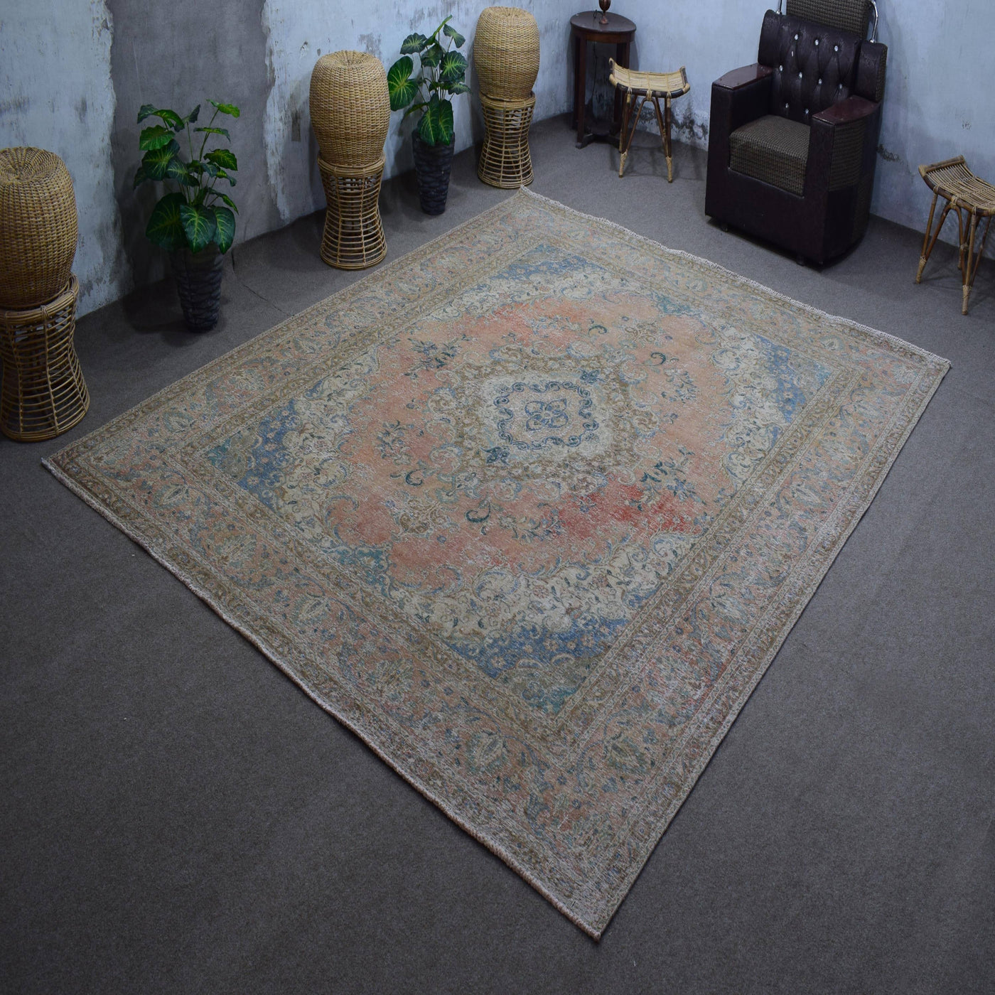 Hand knotted Persian rug photographed at an angle showing overall medallion layout and distressed vintage palette