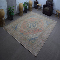 Hand knotted Persian rug photographed at an angle showing overall medallion layout and distressed vintage palette
