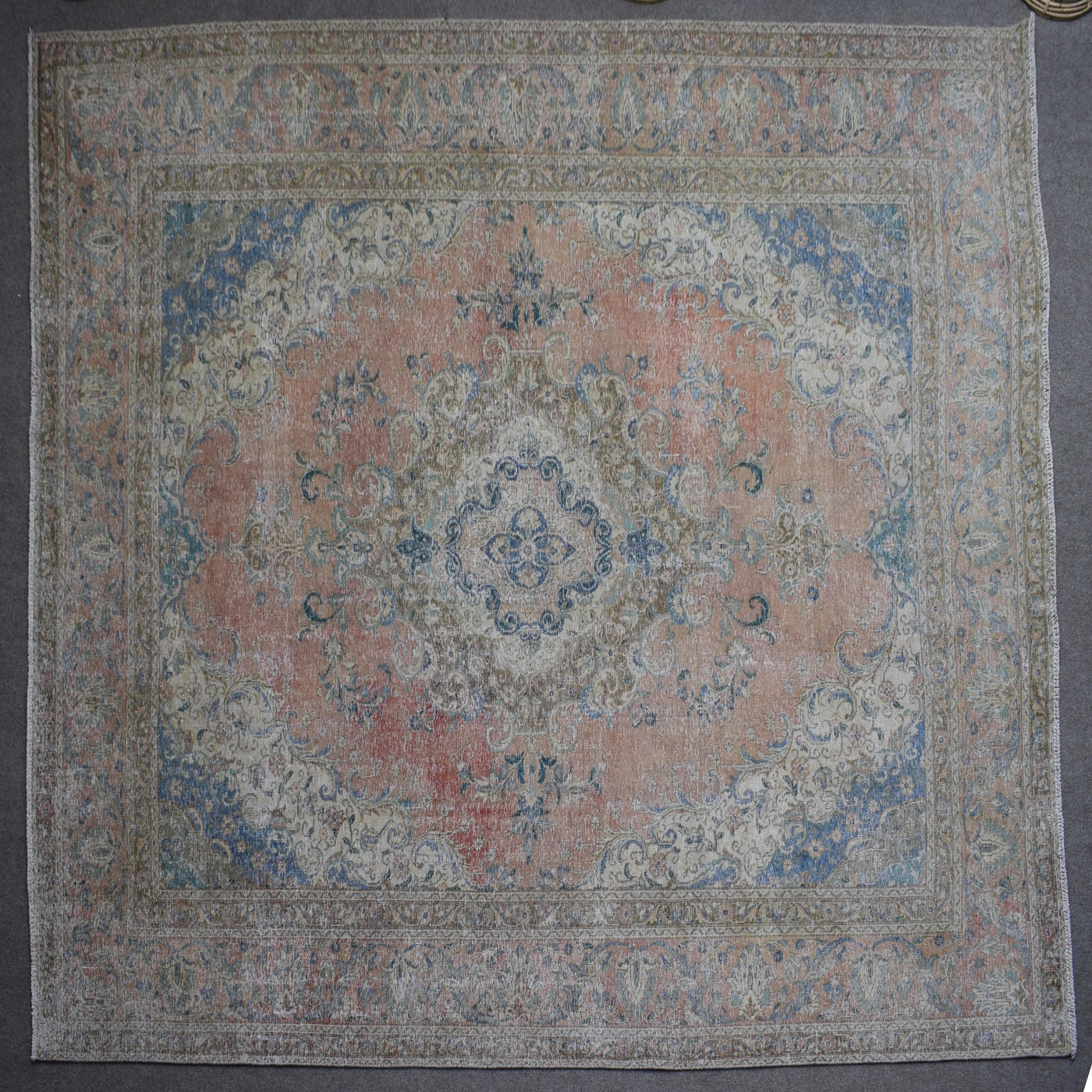 Macro close up of Persian rug pile showing worn wool texture and faded pattern