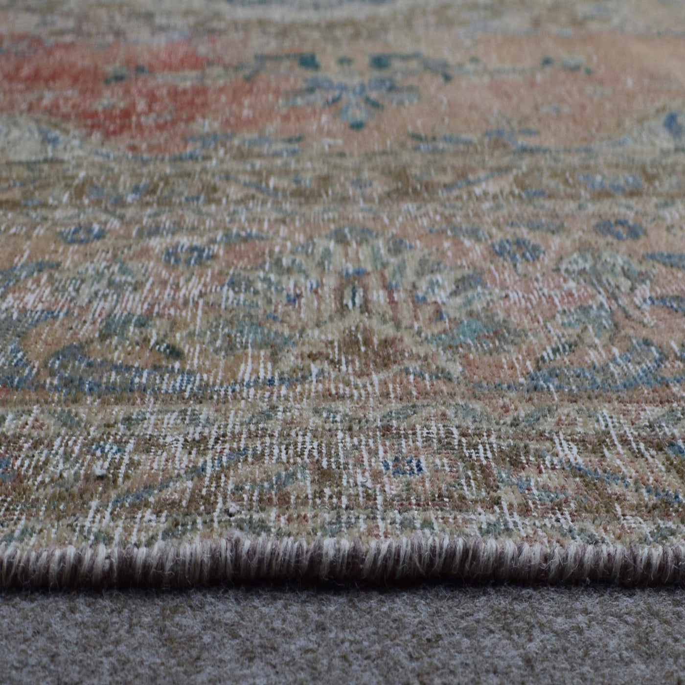 Detailed view of Persian rug medallion highlighting blue ornamental motifs and vintage patina