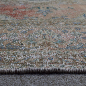 Detailed view of Persian rug medallion highlighting blue ornamental motifs and vintage patina