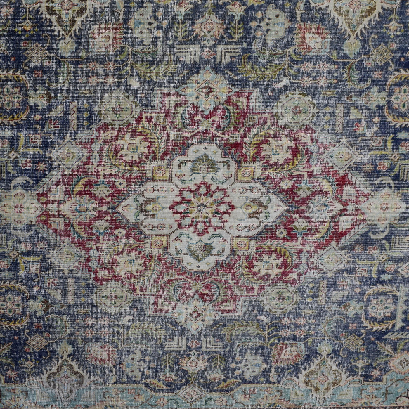 Detailed view of vintage Persian rug medallion featuring traditional Persian floral patterns on navy field