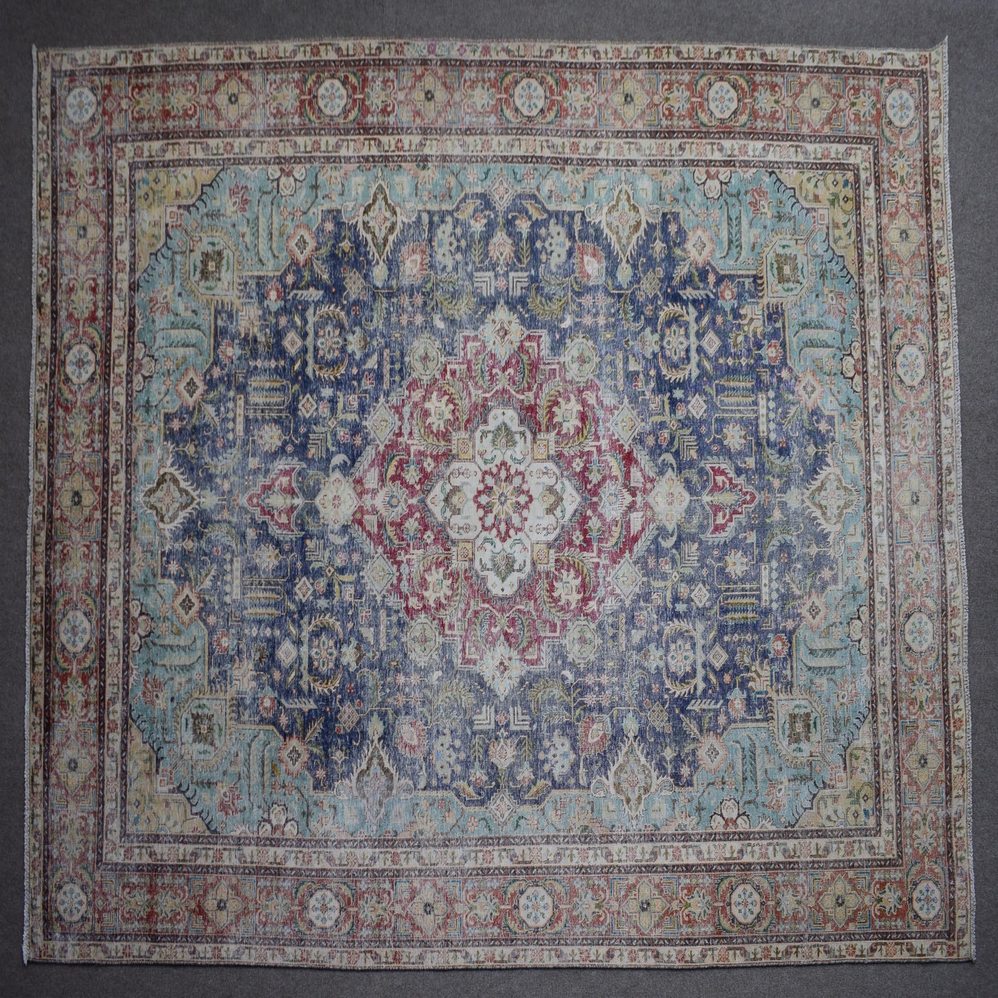 Close up of Persian rug border with colorful floral motifs and intricate guard stripes