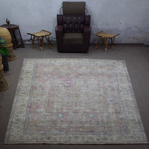 Large distressed vintage Persian rug 292x378 cm styled in interior showing soft neutral tones and worn floral design