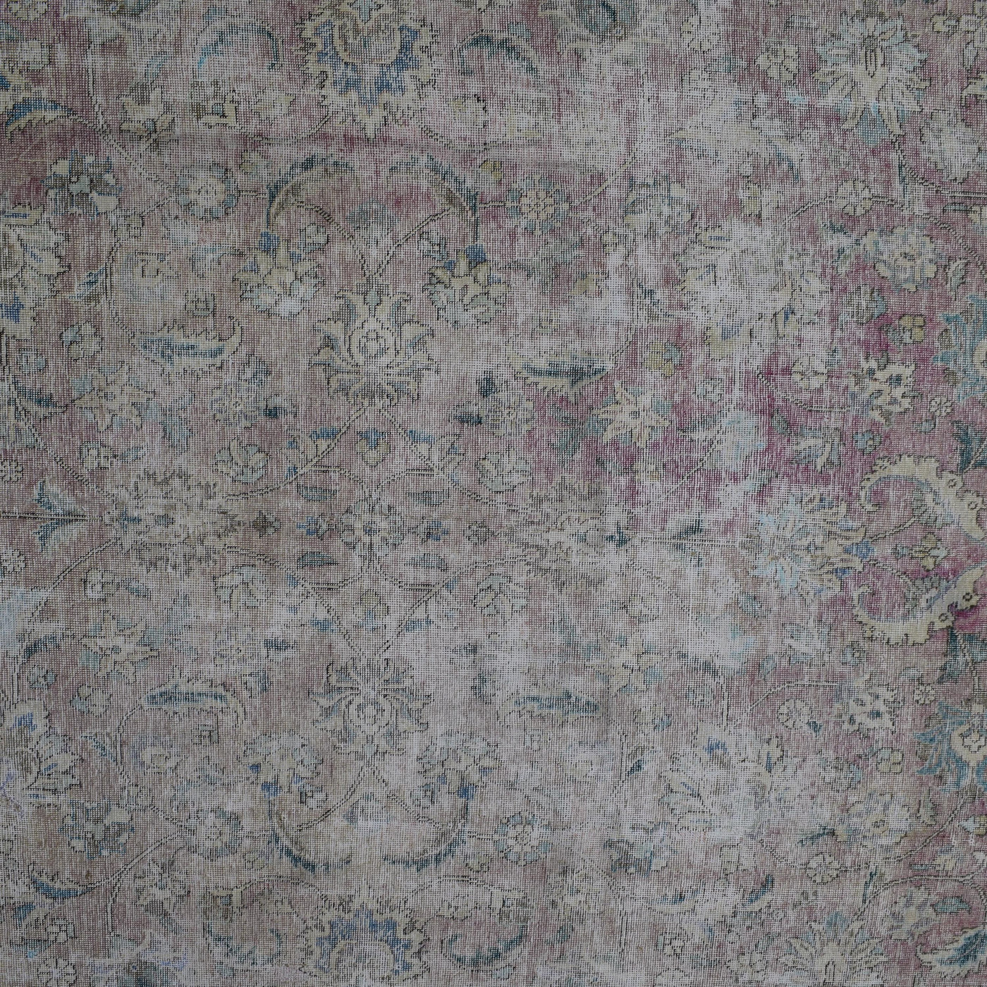Detailed view of vintage Persian rug pattern featuring delicate floral elements and distressed texture