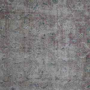 Detailed view of vintage Persian rug pattern featuring delicate floral elements and distressed texture
