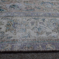 Macro close up of Persian rug pile showing worn wool texture and faded vintage surface