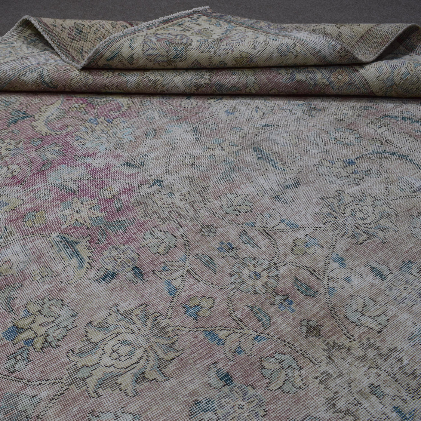 Detailed view of Persian rug floral pattern highlighting soft pastel tones and distressed finish