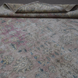 Detailed view of Persian rug floral pattern highlighting soft pastel tones and distressed finish