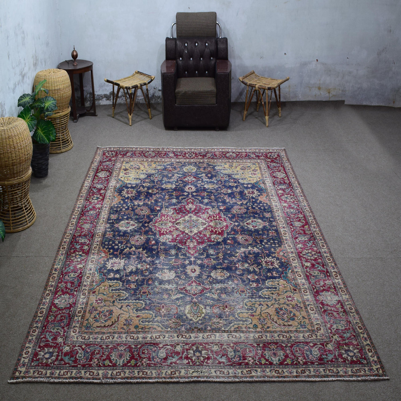 Large distressed vintage Persian rug 245x336 cm styled in interior showing navy background and ornate floral medallion