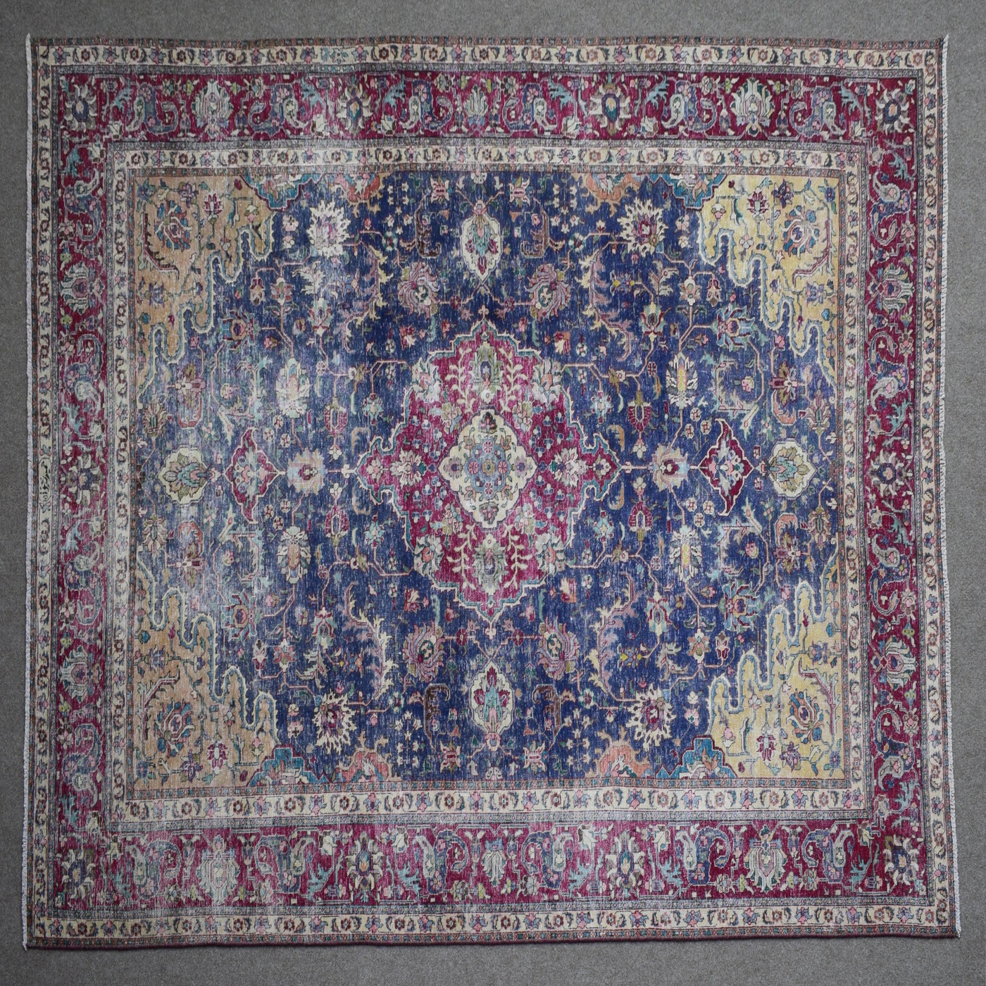 Close up of Persian rug border with colorful floral motifs and intricate guard stripes