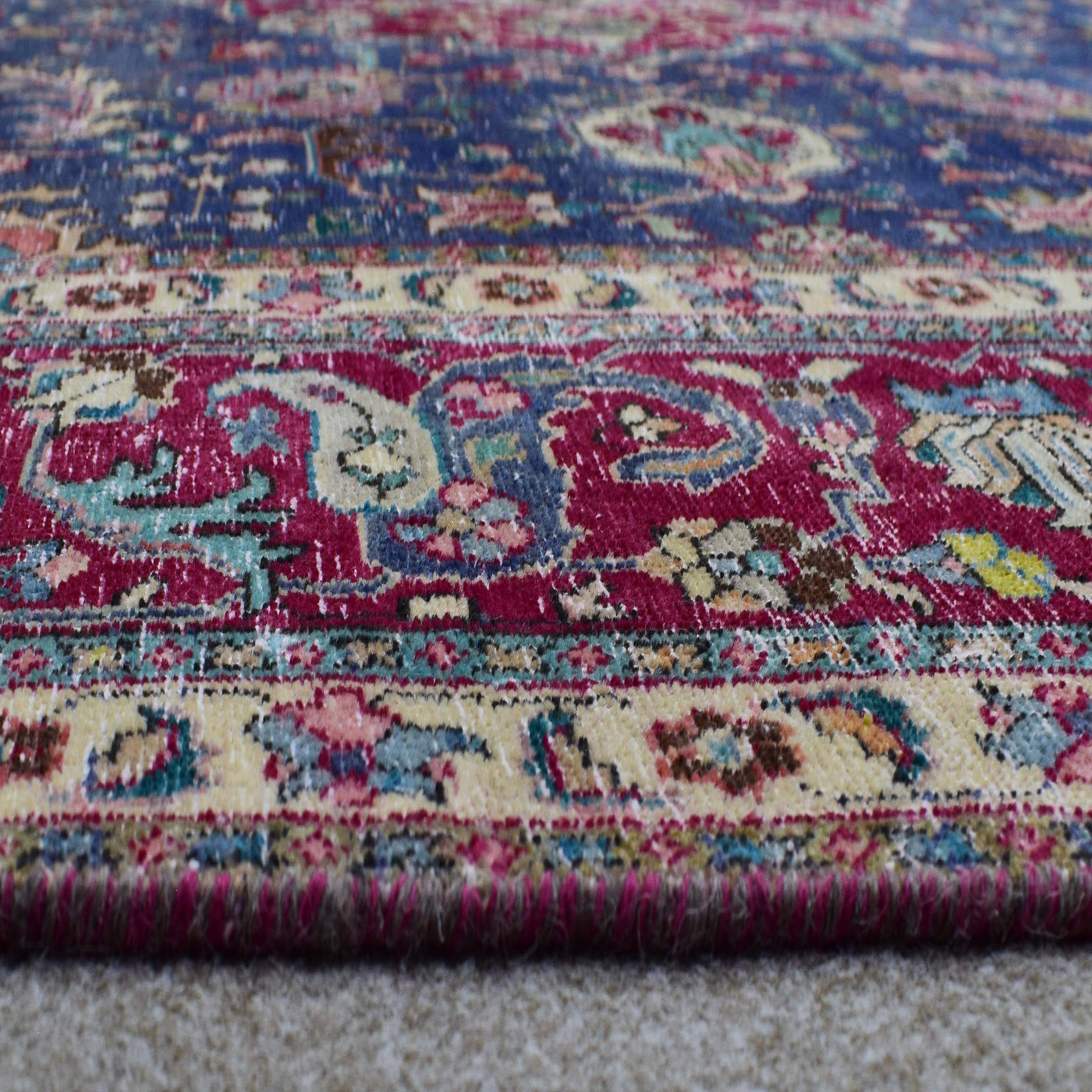 Macro detail of Persian rug medallion highlighting dense floral elements and wool texture