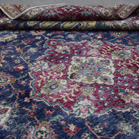 Detailed view of distressed Persian rug pattern with navy background and ornamental motifs