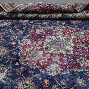 Detailed view of distressed Persian rug pattern with navy background and ornamental motifs