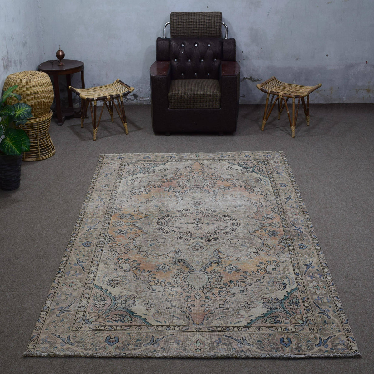 Small distressed vintage Persian rug 183x275 cm styled in interior showing soft neutral tones and floral medallion design