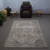 Small distressed vintage Persian rug 183x275 cm styled in interior showing soft neutral tones and floral medallion design