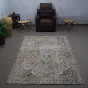 Small distressed vintage Persian rug 183x275 cm styled in interior showing soft neutral tones and floral medallion design