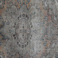 Detailed view of vintage Persian rug pattern featuring traditional floral medallion on faded ivory background