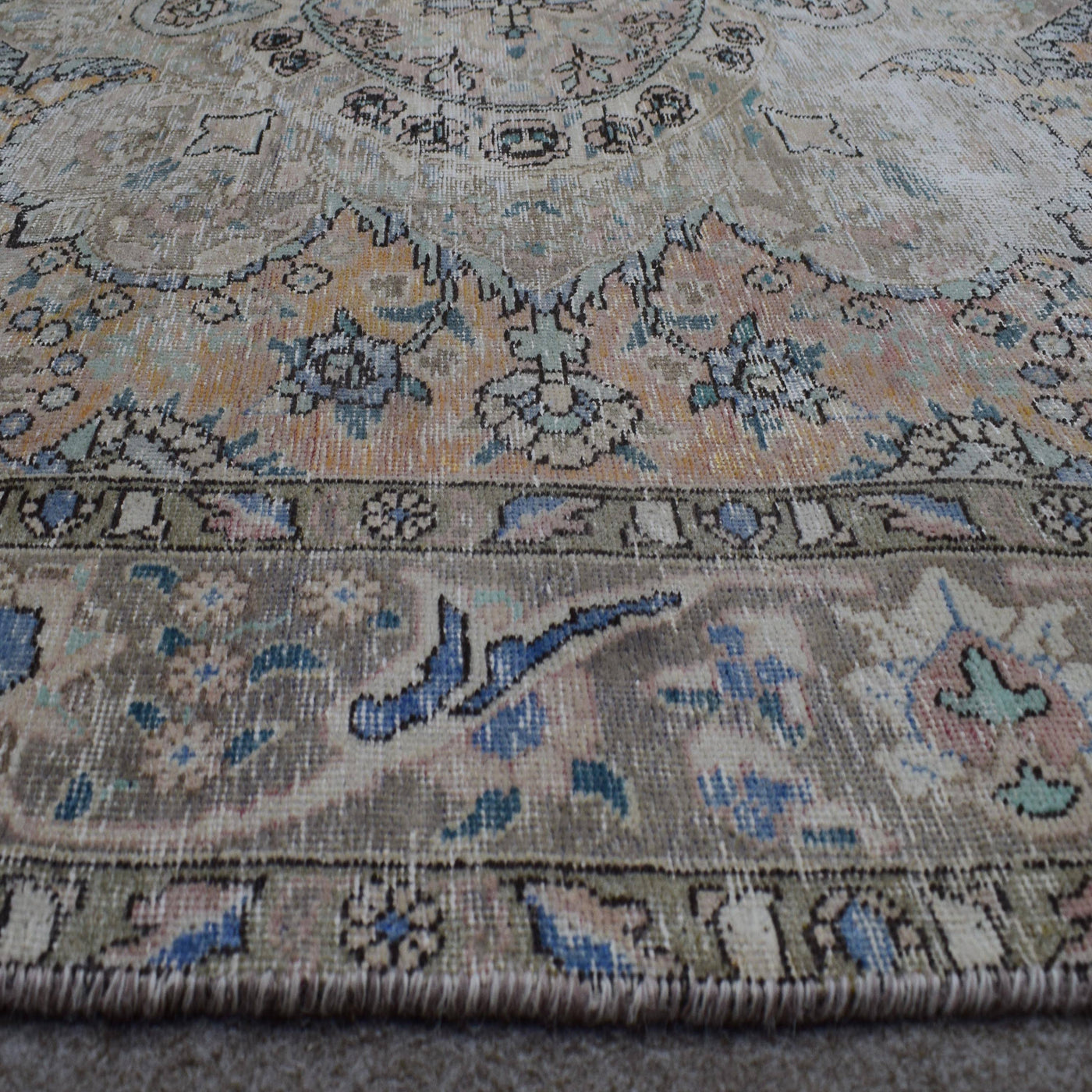 Macro detail of Persian rug medallion highlighting delicate floral elements and wool texture