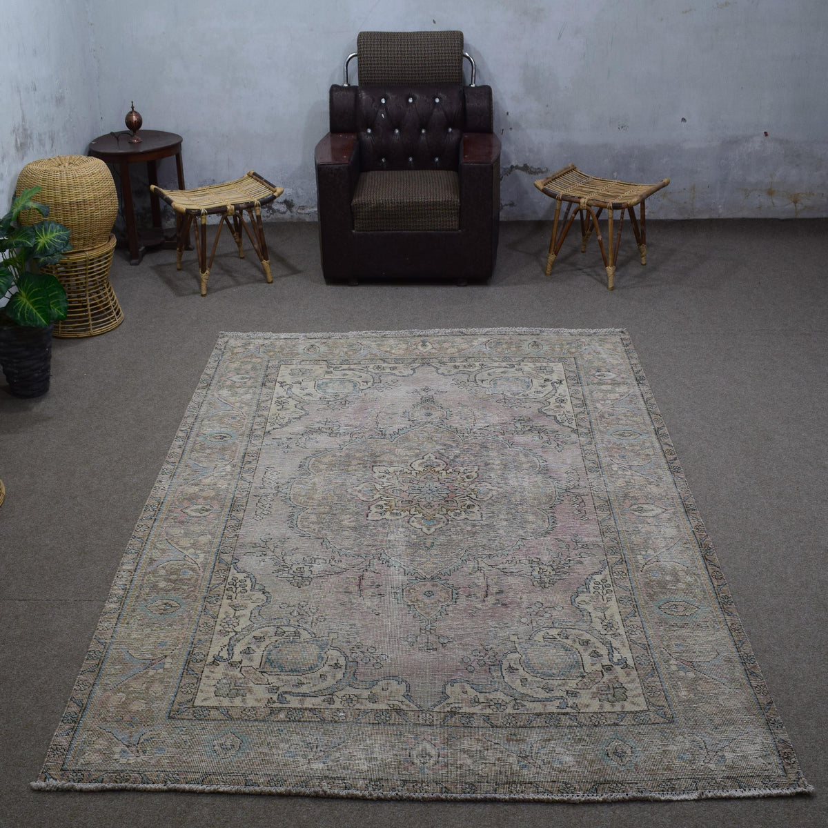 Small distressed vintage Persian rug 198x285 cm styled in interior showing soft neutral tones and worn floral pattern
