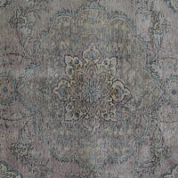 Detailed view of vintage Persian rug pattern featuring intricate floral medallion on faded ivory background