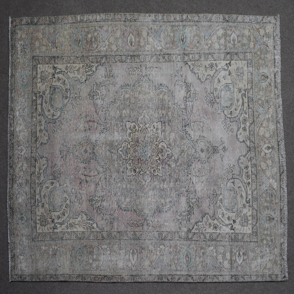 Close up of Persian rug border with subtle blue floral motifs and guard stripes