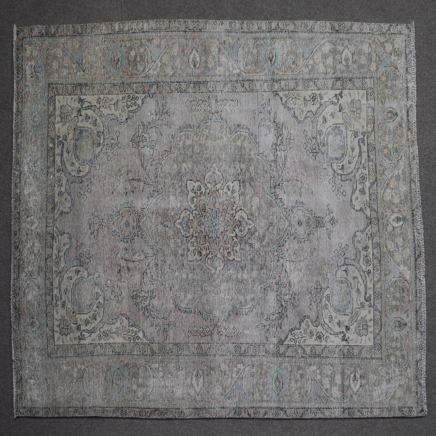 Close up of Persian rug border with subtle blue floral motifs and guard stripes