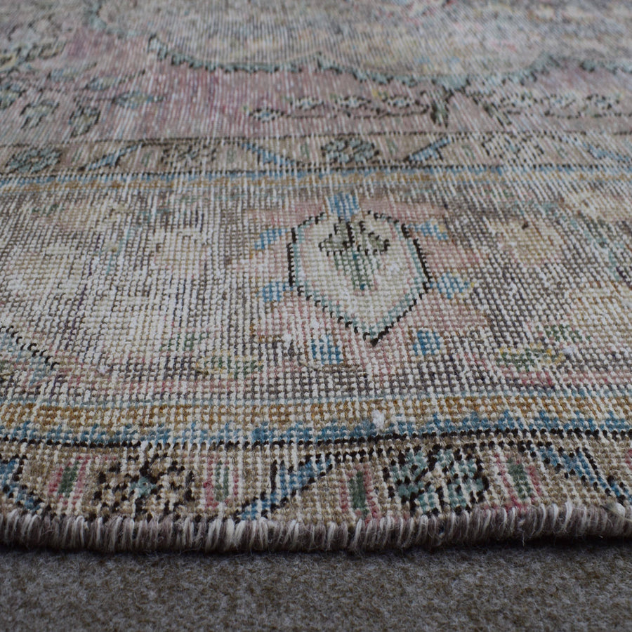 Macro detail of Persian rug medallion highlighting worn wool texture and faded pattern