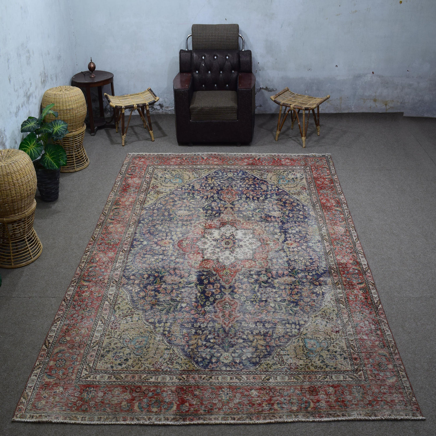Large distressed vintage Persian rug 237x355 cm styled in interior showing navy background and classic medallion design