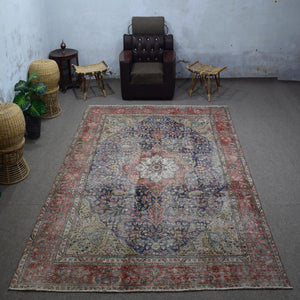 Large distressed vintage Persian rug 237x355 cm styled in interior showing navy background and classic medallion design