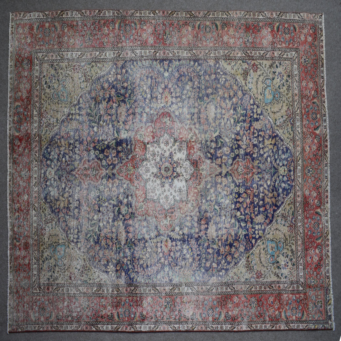 Close up of Persian rug border with colorful floral motifs and intricate guard stripes