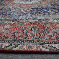Macro detail of Persian rug medallion highlighting dense floral elements and wool texture