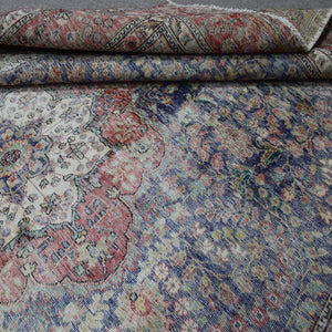 Detailed view of distressed Persian rug pattern with navy background and ornamental motifs