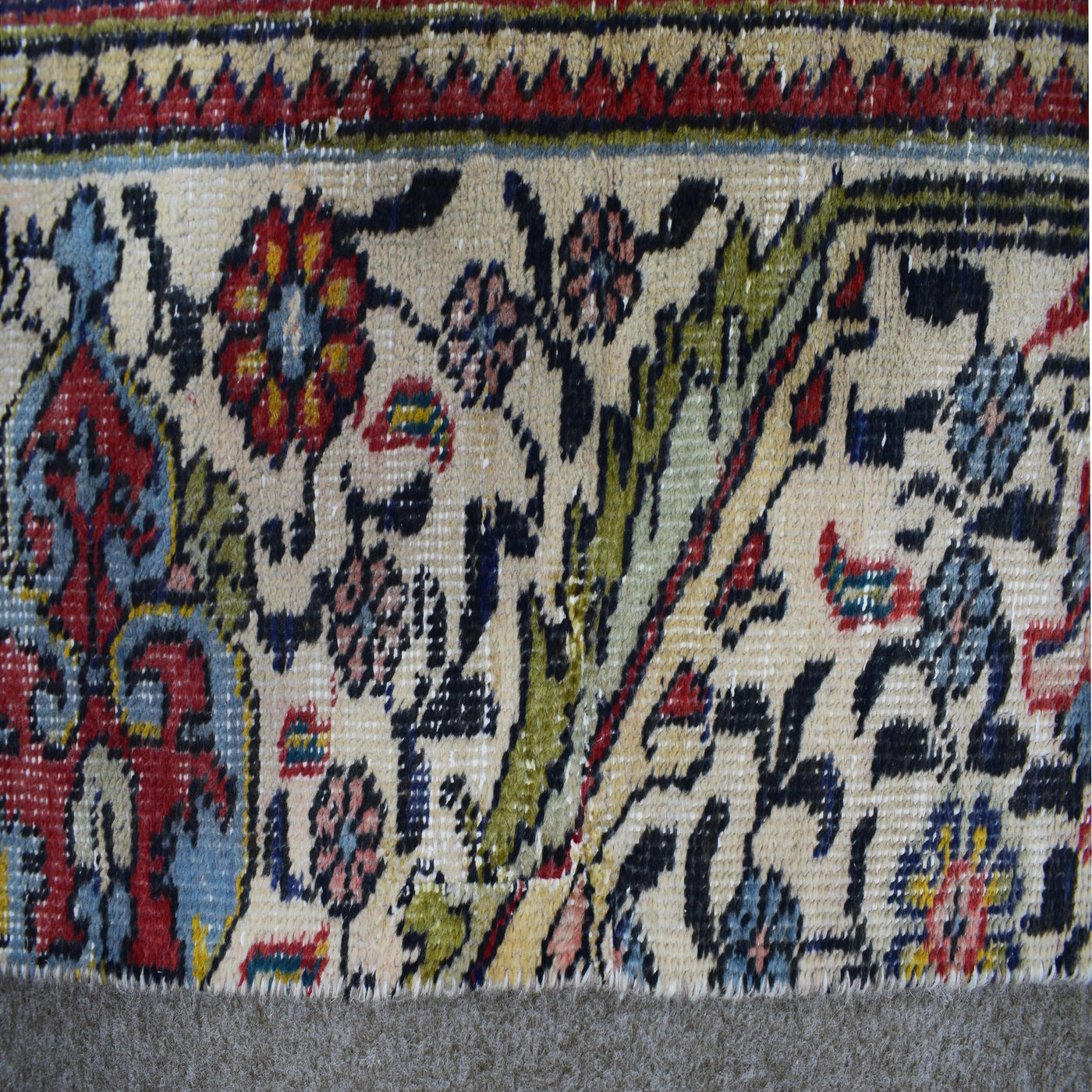 Detailed view of Persian rug floral pattern with colorful motifs on ivory background