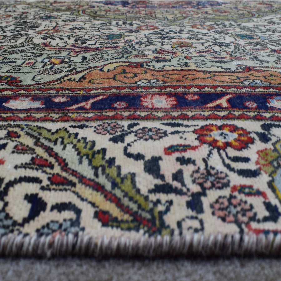 Close up of Persian rug border with vibrant floral motifs and intricate guard stripes