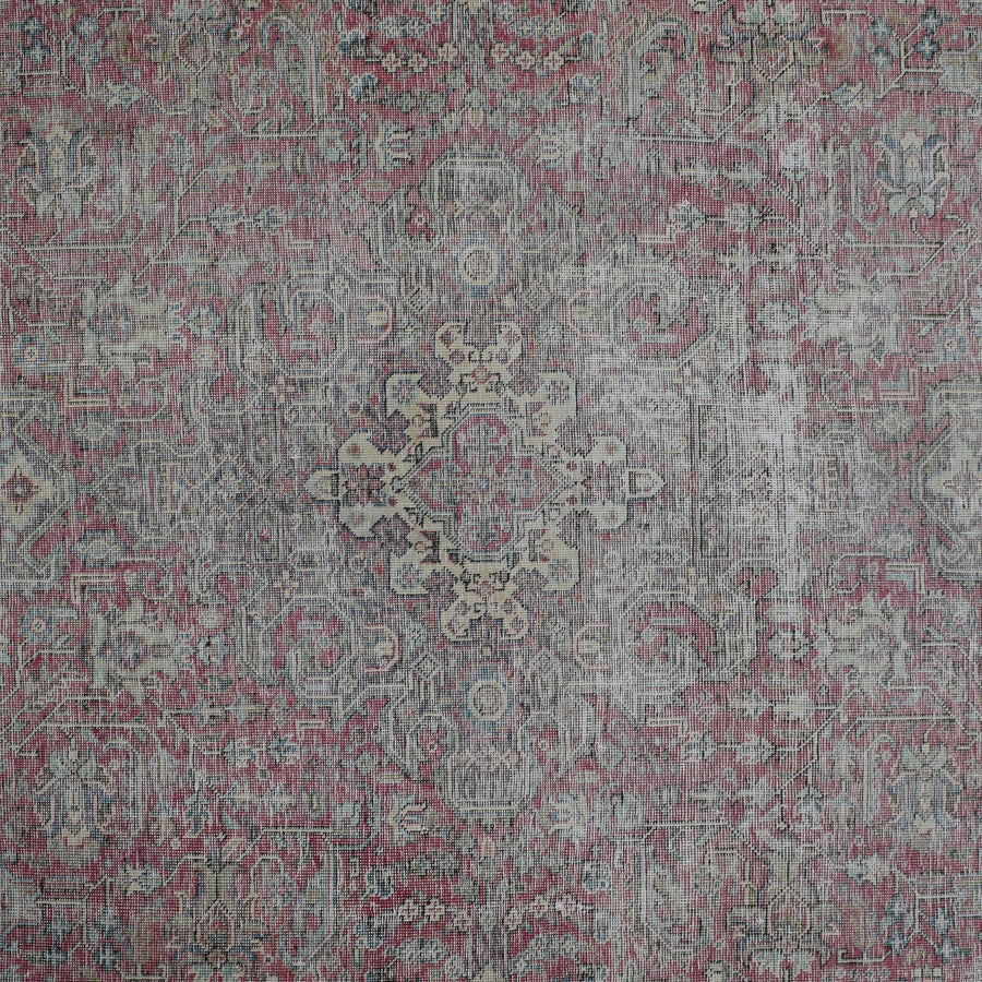 Detailed view of vintage Persian rug pattern featuring delicate medallion and floral elements